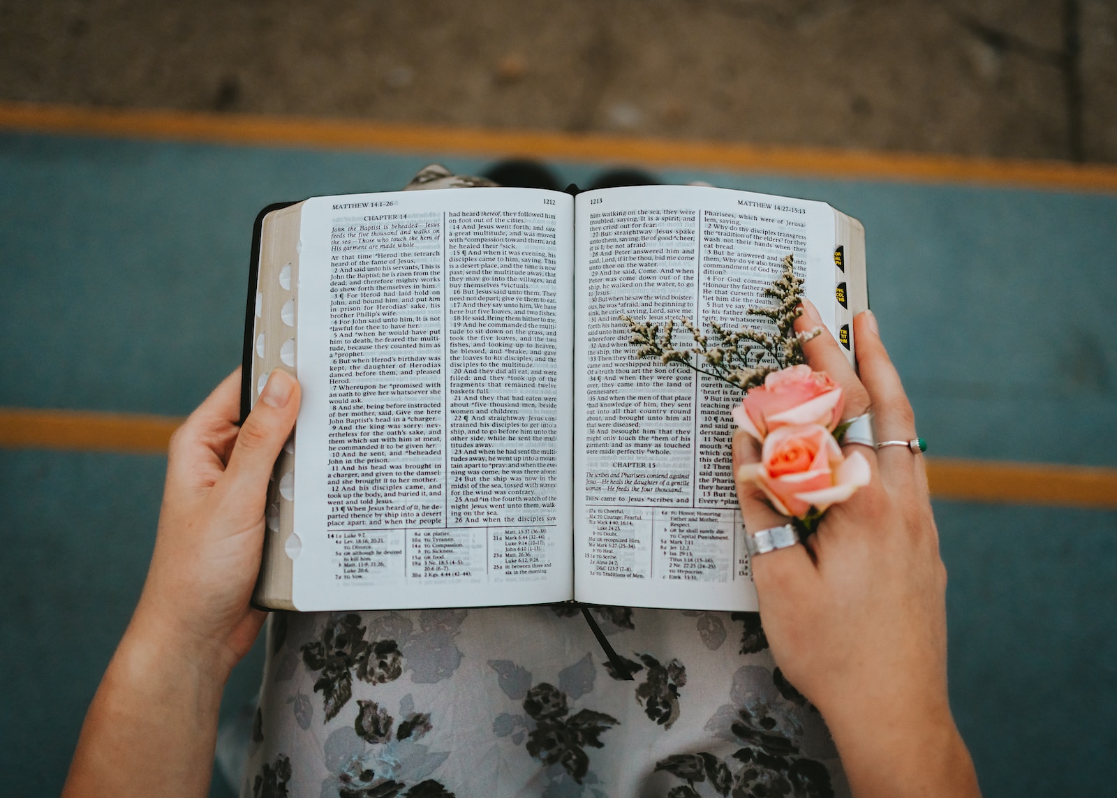 Photo by Bailey Burton a person holding a book with a flower on it